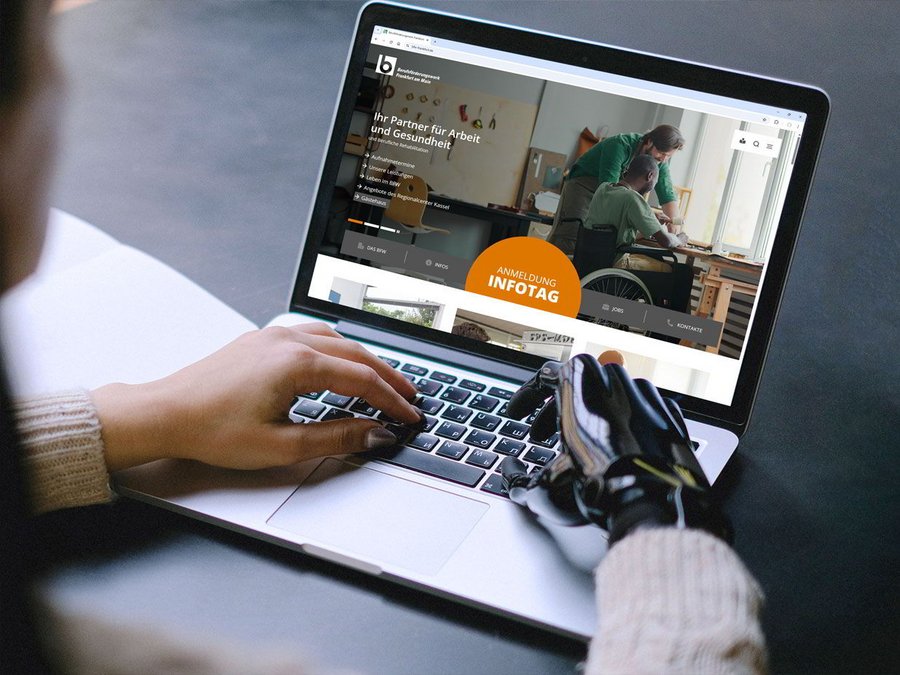 Eine Frau mit einer Armprothese sitzt vor ihrem Laptop und betrachtet die neue barrierefreie Internetseite des BFW-Frankfurt.
