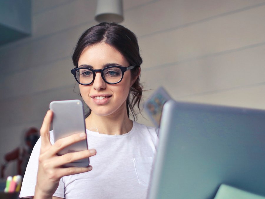 Junge Frau mit Smartphone und der barrierefreien Anwendung Servicekonto NRW