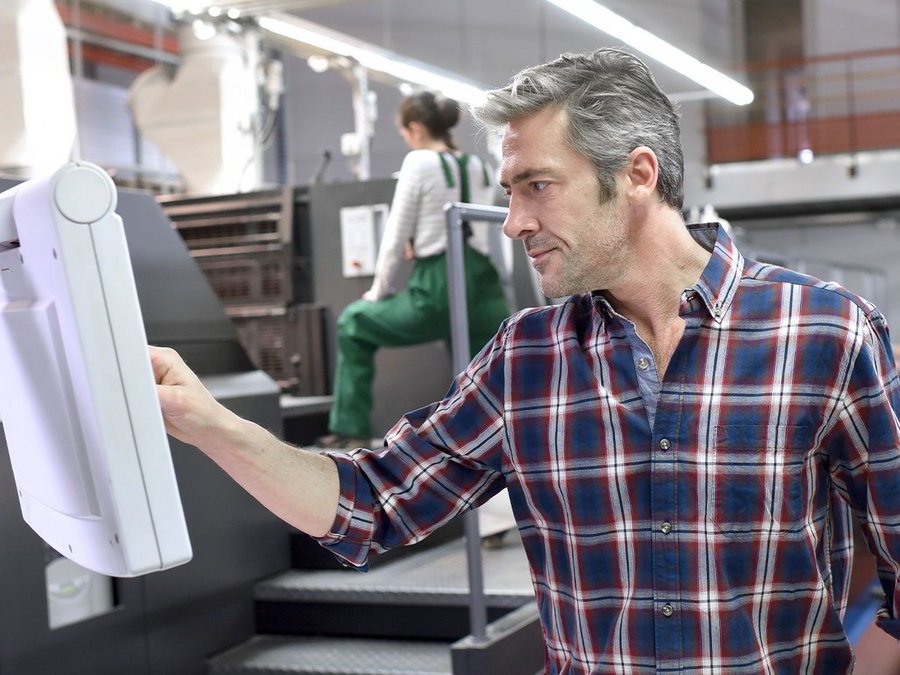 Ein Mann im Ausbildungszentrum des BFW-Frankfurt arbeitet in einer Werkstatt an einer computerisierten Maschine
