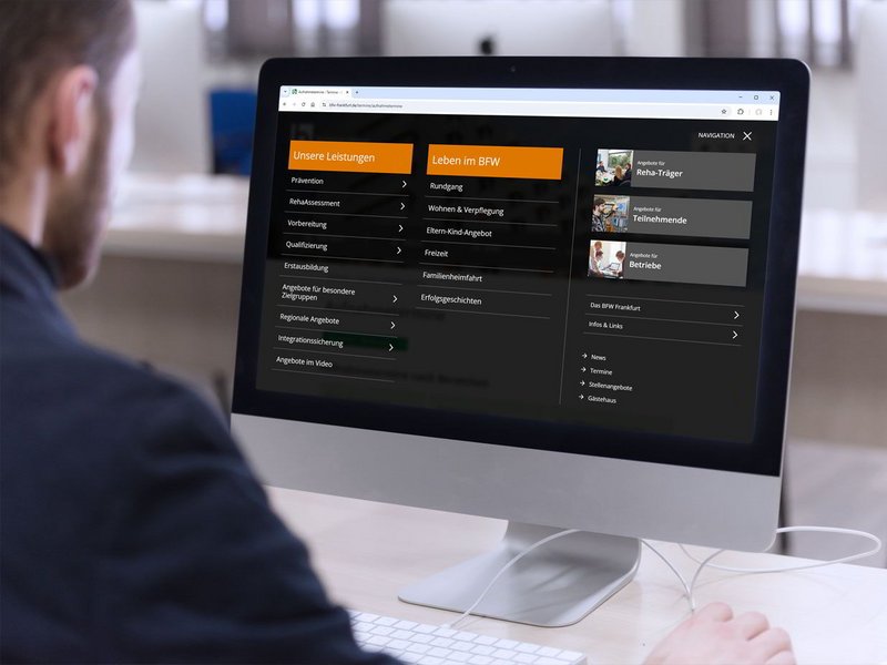 Ein Mann sitzt vor seinem Computer und betrachtet die neue barrierefreie Internetseite des BFW-Frankfurt.